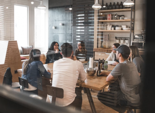 Group of People Sitting Around a Modern Conference Table